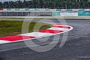 Curving asphalt red and white kerb of a race track detail