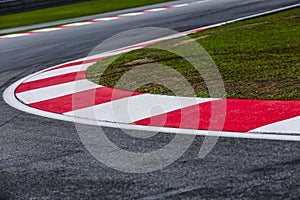 Curving asphalt red and white kerb of a race track detail