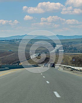 Curving asphalt road between Baku and Shamakhi districts and hills in background, Azerbaijan