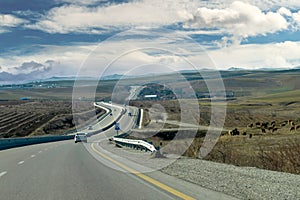 Curving asphalt road between Baku and Shamakhi districts and hills in background, Azerbaijan