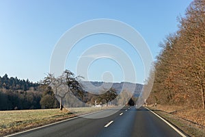 Curving road between fields and trees in Germany LanggÃÂ¶ns in Winter