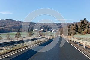 Curving road between fields and trees in Germany LanggÃÂ¶ns in Winter
