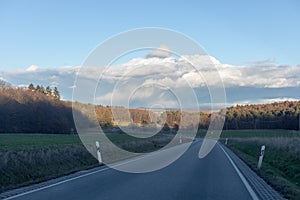 Curving road between fields and trees in Germany LanggÃÂ¶ns in Winter