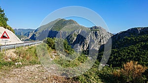 Curving road with a road sign and beautiful mountains