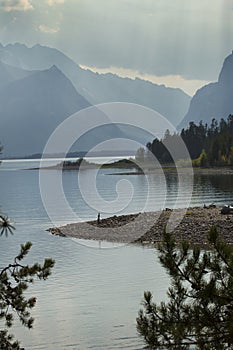 Curving shoreline of Jackson Lake, sun rays, Jackson Hole, Wyomi