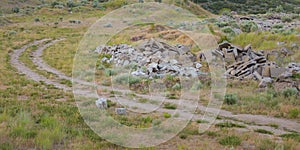 Curving trail on a grassy ground with piled stones