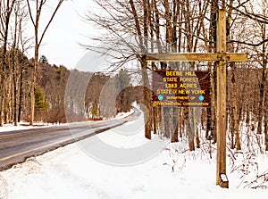 Curving white snowy mountain road to state forest