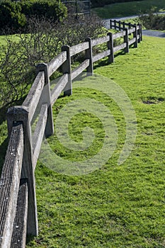 Curving wooden fence on grass