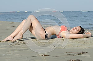 curvy body type in bikini and good looking lady lie on sand