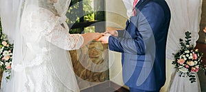 Curvy bride in white lace dress and a groom. Wedding couple at the ceremony. Man and wife giving marriage vows. Engagement rings.
