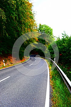 curvy country road around Laacher See in autumn forest