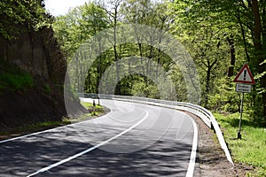 curvy country road with a warning sign