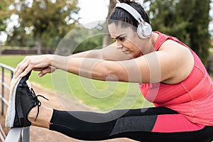 Curvy girl doing stretching day routine outdoor at city park - Focus on face