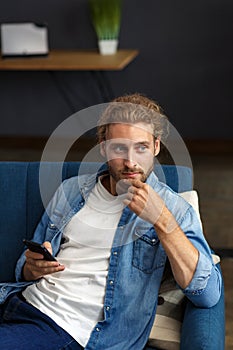 Curvy guy using smartphone and smiling. Happy man using mobile phone apps, texting message, browsing internet, looking