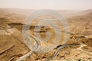 Curvy highway in the Great Rift Valley with desert landscape in Jordan