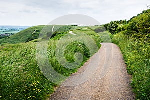 Curvy path on hilly landscape on cloudy day