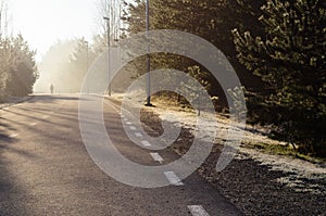 Curvy road with man silhouette on sunny morning