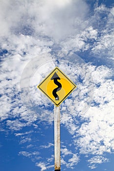 Curvy Road Sign on blue sky background with clipping path.