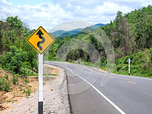 Curvy road sign to the mountain