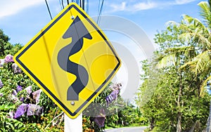 Curvy road sign to the mountain in rural area