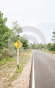 Curvy road sign to the mountain in rural area