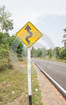 Curvy road sign to the mountain in rural area