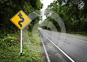 Curvy road sign to the mountain in rural area