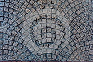 Curvy textures of dark orange-gray square stones on an outdoor floor