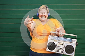 Curvy woman listening music in boombox vintage stereo