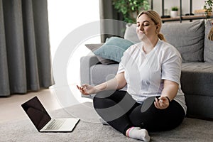 Curvy woman meaditating at home