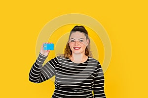 Curvy woman smiling with a credit card in her hand