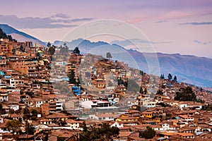 Cusco City houses with mountain at sunset.