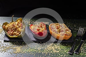 Cuscus, roasted peppers fresh from the oven stuffed with couscous with vegetables dark food version