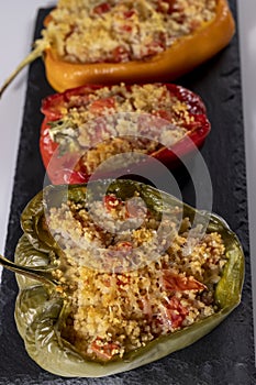 Cuscus, roasted peppers in the oven and stuffed with couscous with vegetables white background
