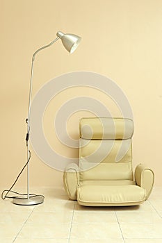 Cushion seat for sitting on the floor with lamp over light beige wall