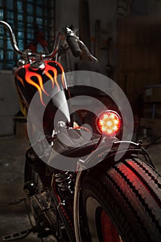Custom bobber motorbike in an workshop garage.