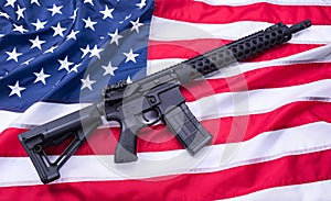 Custom built AR-15 carbine on American flag surface, background. Studio shot.