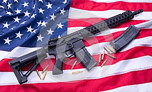 Custom built AR-15 carbine, bullets and a magazine on American flag surface, background. Studio shot.