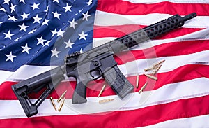 Custom built AR-15 carbine and bullets on American flag surface, background. Studio shot.