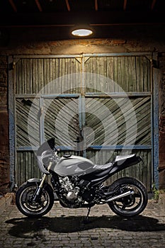 Custom caferacer motorbike on an old garage door background.