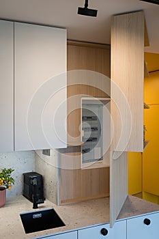 Custom kitchen cabinet with hidden circuit breaker box in urban apartment