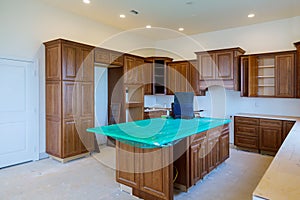 Custom kitchen cabinets in various stages of installation base for island in center