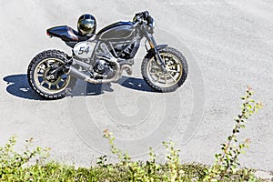 Custom made scrambler style cafe racer with helmet standing on r