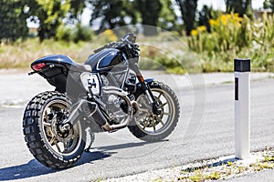 Custom made scrambler style cafe racer standing on road