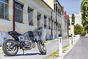 Custom made scrambler style cafe racer standing on road photo