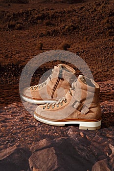 Custom made women`s outdoor trekking suede boots on mountain desert backdrop