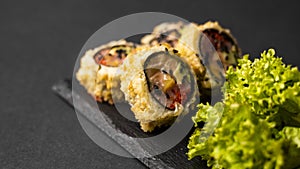 Custom sushi roll in tempura with nori, fresh salmon, tuna, avocado, masago caviar, drizzled with pineapple sauce with