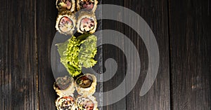 Custom sushi roll in tempura with nori, fresh salmon, tuna, avocado, masago caviar, drizzled with pineapple sauce with