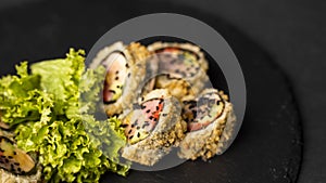 Custom sushi roll in tempura with nori, fresh salmon, tuna, avocado, masago caviar, drizzled with pineapple sauce with