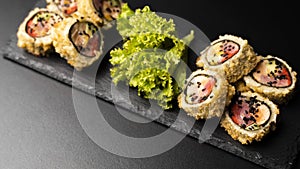 Custom sushi roll in tempura with nori, fresh salmon, tuna, avocado, masago caviar, drizzled with pineapple sauce with